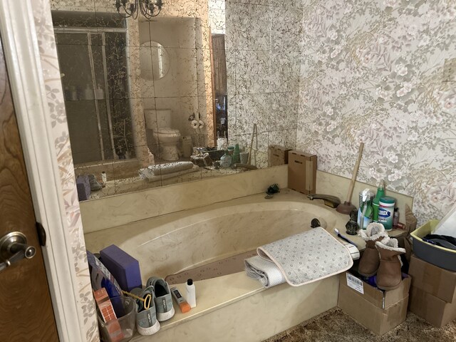 bathroom featuring wallpapered walls and a garden tub