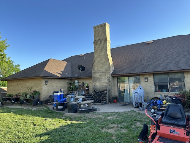 rear view of house with a yard, a chimney, a patio area, and brick siding