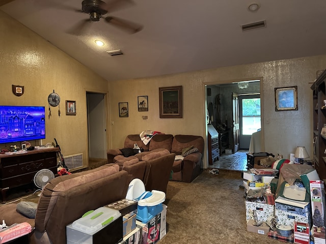 living area with a textured wall, visible vents, carpet floors, vaulted ceiling, and a ceiling fan