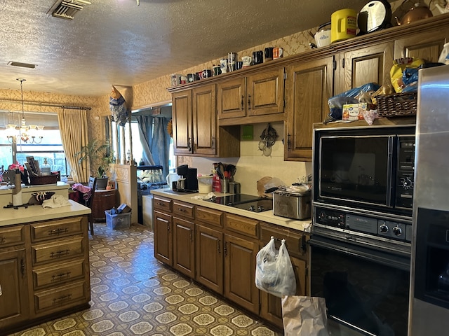kitchen featuring a textured ceiling, visible vents, a chandelier, light countertops, and black appliances