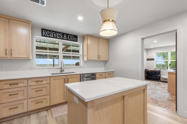 kitchen with a sink, tasteful backsplash, light brown cabinetry, visible vents, and light wood-style flooring