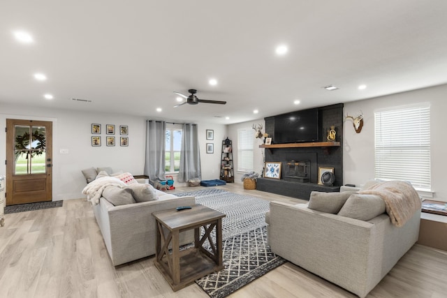living room with a brick fireplace, recessed lighting, light wood finished floors, and a ceiling fan
