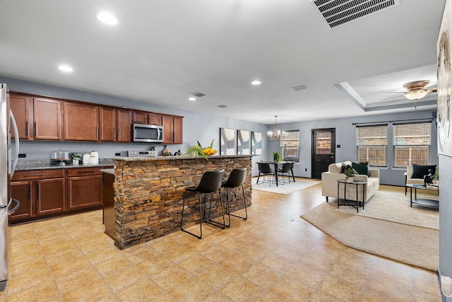 kitchen featuring dark stone countertops, a breakfast bar area, visible vents, stainless steel appliances, and recessed lighting
