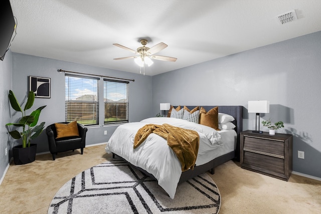 bedroom featuring light colored carpet, visible vents, a ceiling fan, and baseboards