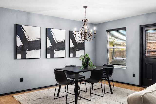 dining space featuring a notable chandelier and baseboards