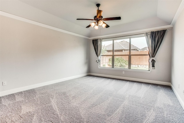 carpeted spare room featuring ceiling fan, crown molding, a tray ceiling, and baseboards