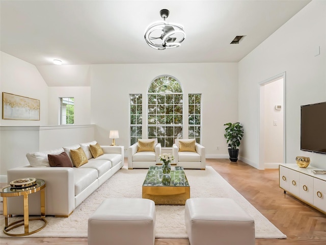 living area with baseboards and visible vents