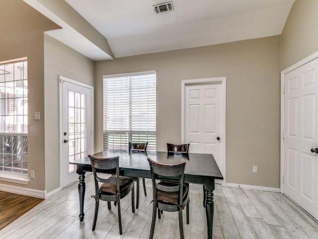 dining space with baseboards, visible vents, and light wood-style floors