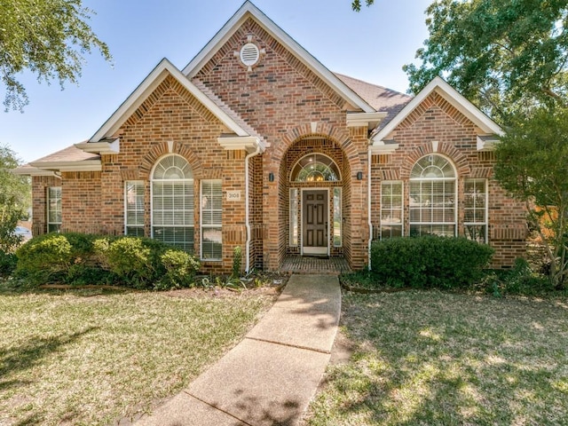 view of front facade featuring a front lawn and brick siding