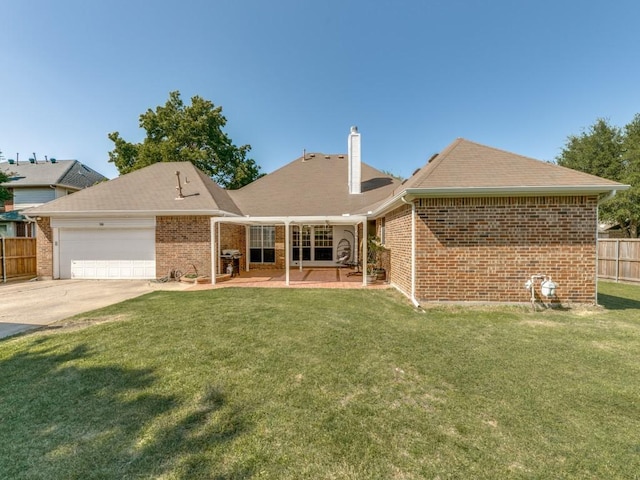 back of house with a yard, brick siding, fence, driveway, and an attached garage