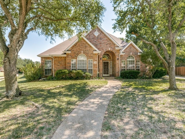 single story home with brick siding, fence, and a front lawn