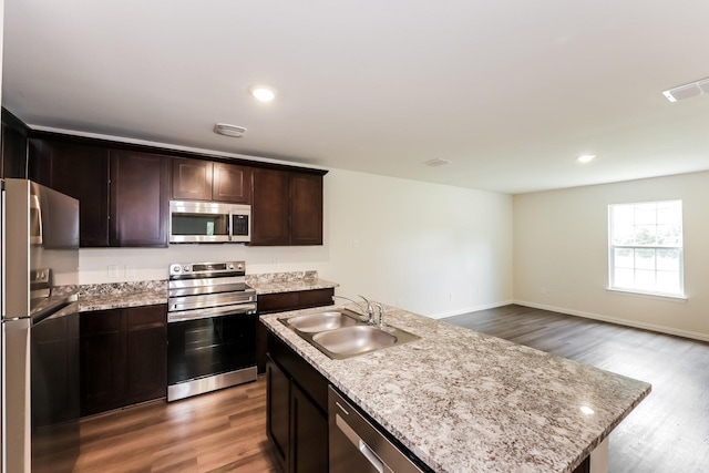 932 Dawson St, Waco, TX 76704 - kitchen featuring wood finished floors, dark brown cabinets, appliances with stainless steel finishes, and a sink