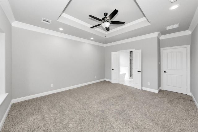 unfurnished bedroom featuring ornamental molding, a raised ceiling, carpet flooring, and baseboards