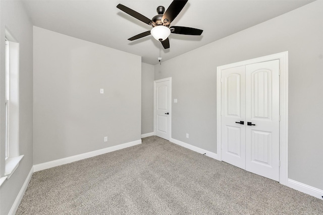 unfurnished bedroom featuring a closet, ceiling fan, carpet floors, and baseboards