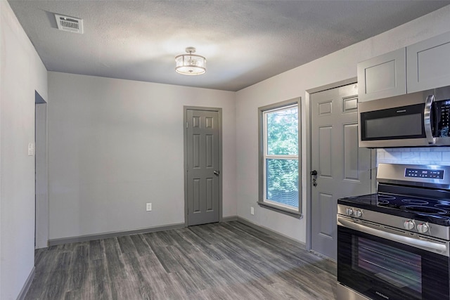 4301 Wilhelm St, Fort Worth, TX 76119 - kitchen with wood finished floors, stainless steel appliances, baseboards, visible vents, and a textured ceiling