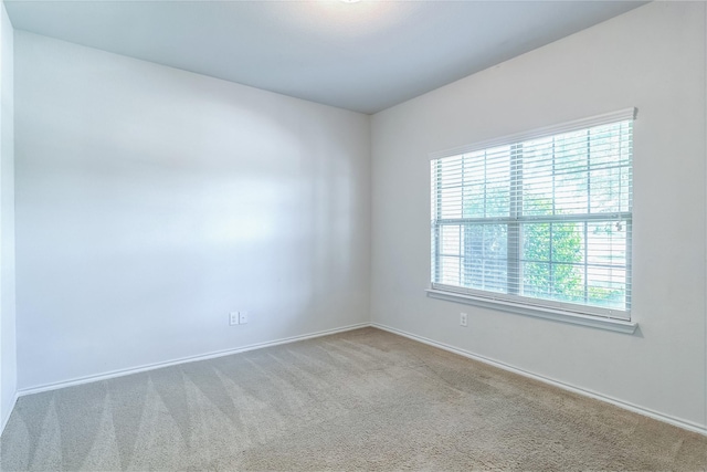 carpeted empty room with baseboards