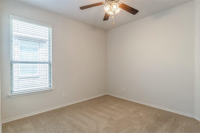 spare room with light colored carpet, a healthy amount of sunlight, and ceiling fan