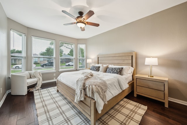 bedroom featuring multiple windows, wood finished floors, and baseboards