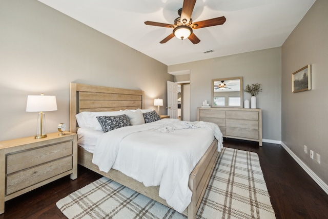 bedroom with a ceiling fan, visible vents, wood finished floors, and baseboards