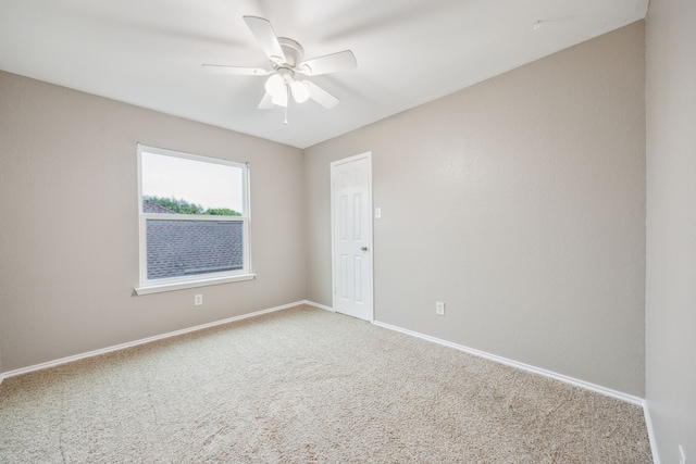 carpeted empty room with a ceiling fan and baseboards