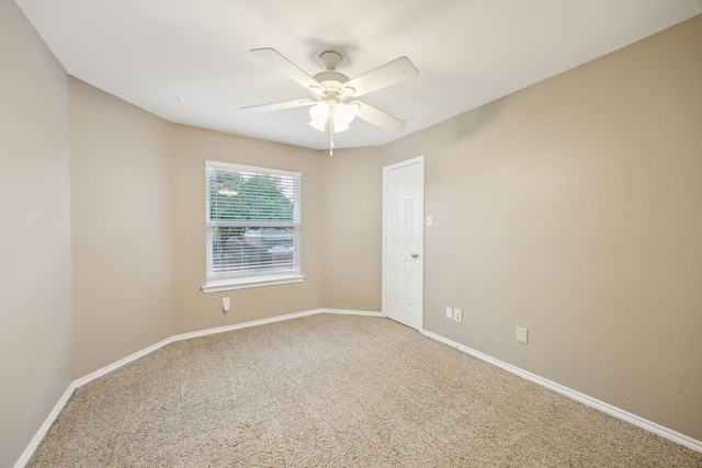 spare room featuring a ceiling fan, carpet flooring, and baseboards