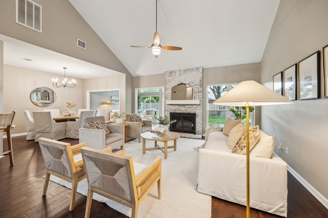 living room with visible vents, wood finished floors, ceiling fan with notable chandelier, and high vaulted ceiling