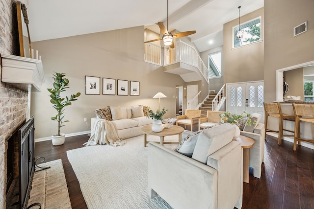 living room featuring visible vents, a fireplace, a ceiling fan, high vaulted ceiling, and stairs