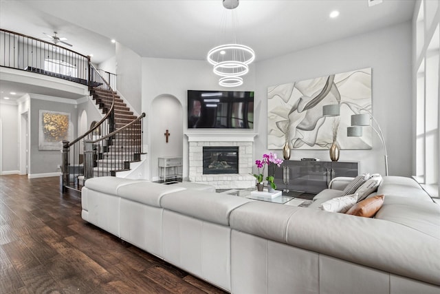 living area featuring baseboards, recessed lighting, a fireplace, wood finished floors, and stairs