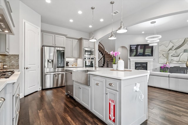 kitchen with recessed lighting, decorative backsplash, stainless steel appliances, a sink, and open floor plan