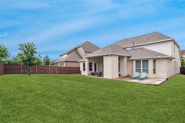 back of property featuring a shingled roof, a patio, brick siding, and a fenced backyard