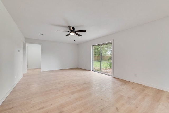 spare room featuring visible vents, a ceiling fan, light wood-style flooring, and baseboards