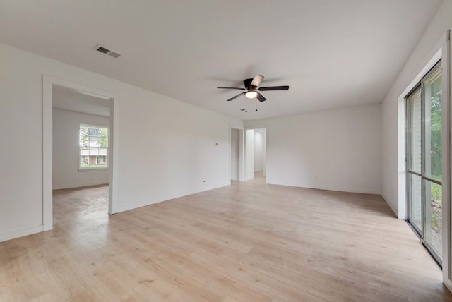 unfurnished room featuring visible vents, a ceiling fan, baseboards, and light wood-style floors