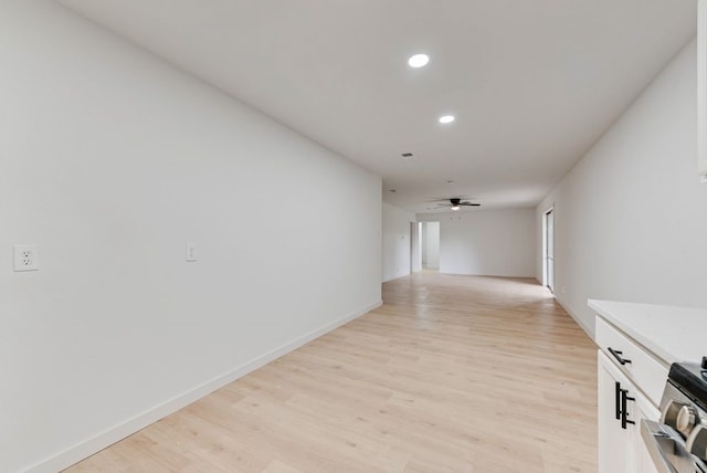 hallway with light wood-type flooring, recessed lighting, and baseboards