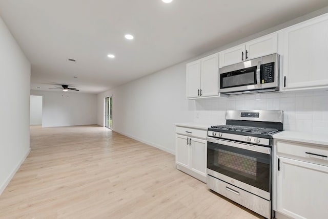 kitchen with light wood finished floors, recessed lighting, stainless steel appliances, decorative backsplash, and white cabinetry