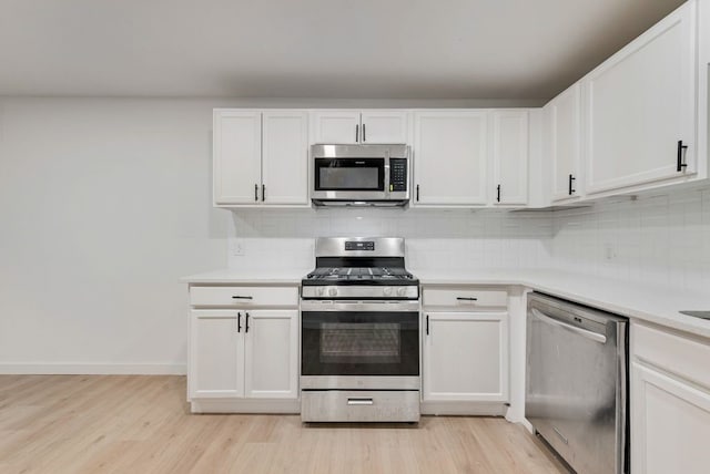 kitchen featuring backsplash, appliances with stainless steel finishes, and light wood-style floors