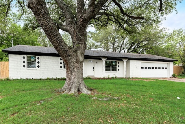 single story home with fence, a front lawn, an attached garage, and brick siding