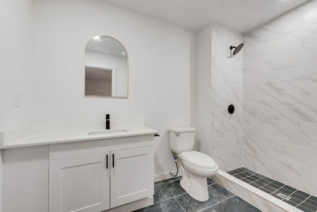 bathroom with vanity, toilet, and tiled shower