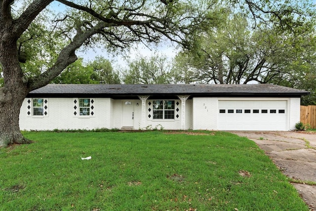 ranch-style house featuring brick siding, a front yard, concrete driveway, and an attached garage