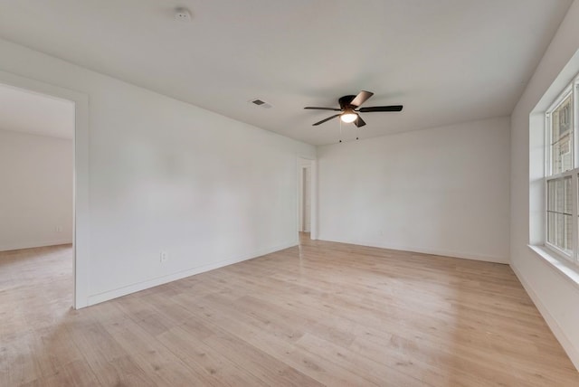 spare room with ceiling fan, light wood-type flooring, and visible vents