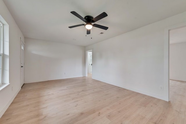 unfurnished room with baseboards, visible vents, ceiling fan, and light wood-style flooring