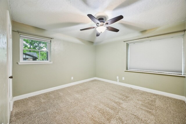 unfurnished room featuring carpet floors, a textured ceiling, ceiling fan, and baseboards