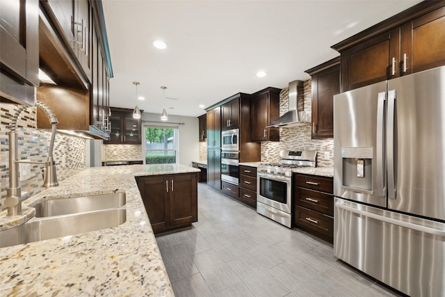 kitchen with wall chimney range hood, backsplash, dark brown cabinetry, and appliances with stainless steel finishes