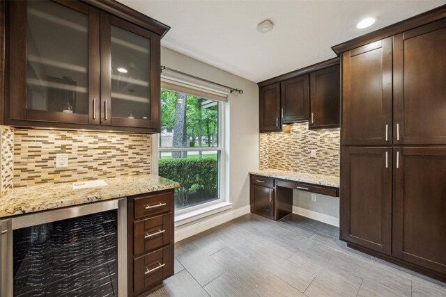 bar with built in study area, beverage cooler, recessed lighting, baseboards, and decorative backsplash