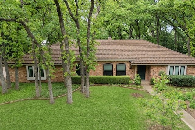 ranch-style house with brick siding and a tile roof