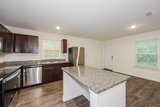 kitchen with dark wood-type flooring, a sink, appliances with stainless steel finishes, and plenty of natural light