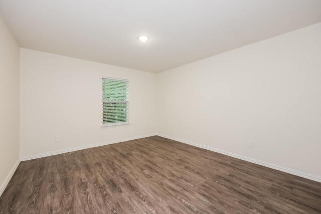 empty room featuring dark wood-style floors, recessed lighting, and baseboards