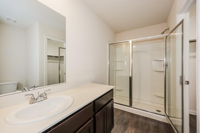 bathroom featuring visible vents, a stall shower, wood finished floors, and vanity