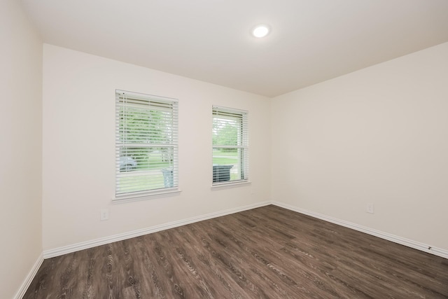 spare room with dark wood-style floors and baseboards