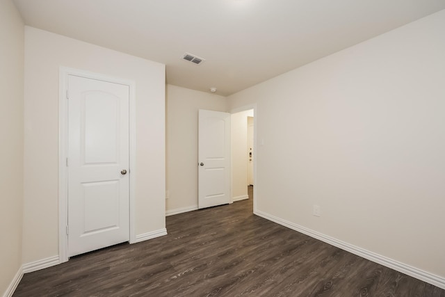 unfurnished bedroom featuring visible vents, baseboards, and dark wood finished floors
