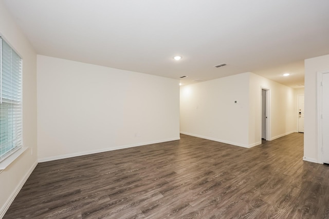 spare room with visible vents, recessed lighting, and dark wood finished floors